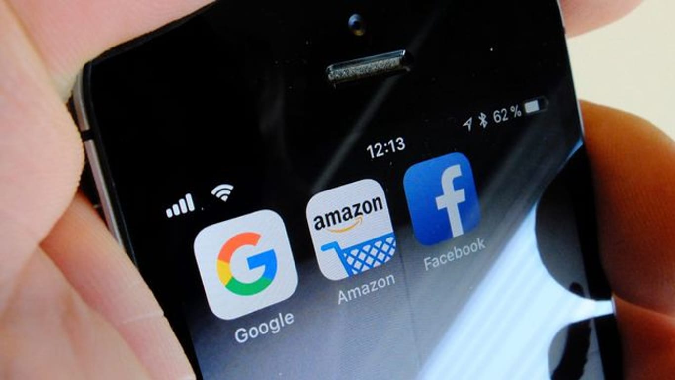 Logos der US-Internetkonzerne Google (l-r), Amazon und Facebook sind auf dem Display eines iPhones.