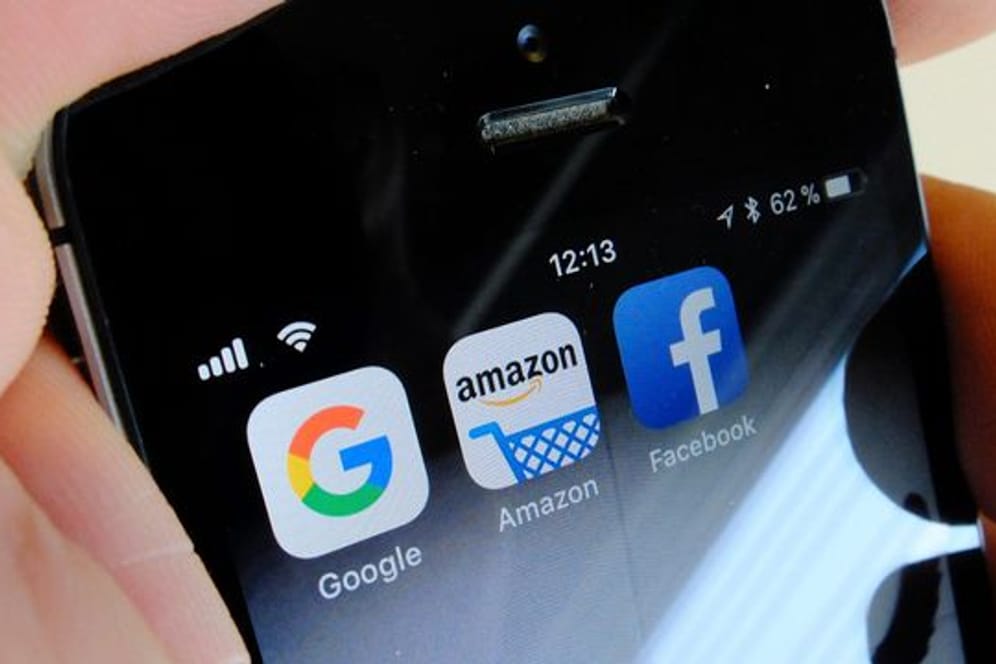 Logos der US-Internetkonzerne Google (l-r), Amazon und Facebook sind auf dem Display eines iPhones.