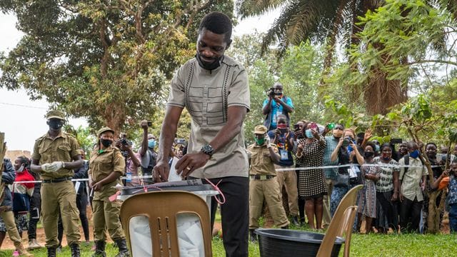 Bobi Wine, Popstar und Präsidentschaftskandidat der Opposition, mit bürgerlichem Namen Robert Kyagulanyi, gibt seine Wahlstimme während der Präsidenten- und Parlamentswahl ab. Bobi Wine, Popstar und Präsidentschaftskandidat der Opposition, mit bürgerlichem Namen Robert Kyagulanyi, gibt seine Wahlstimme während der Präsidenten- und Parlamentswahl ab.