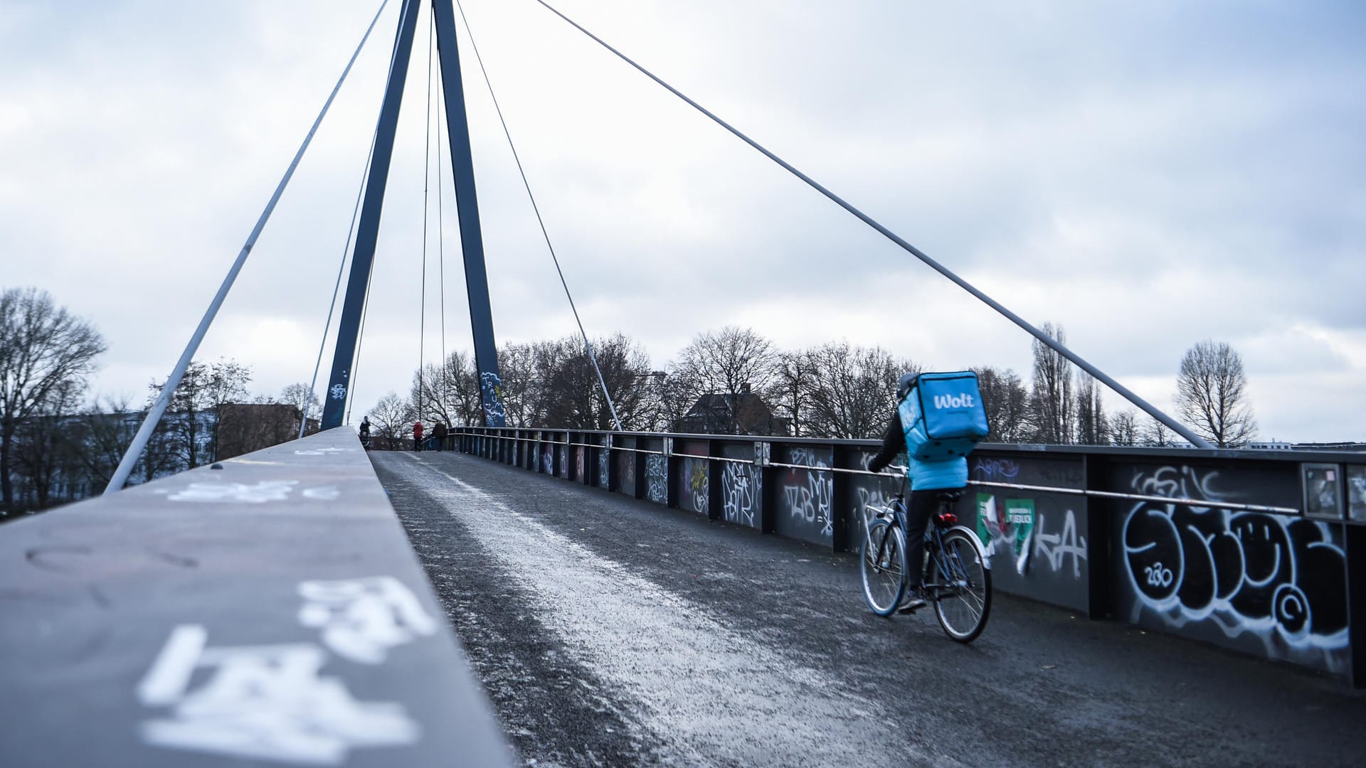 Einsamer Essensbote auf einer Fußgängerbrücke in Berlin: Weil die Infektionszahlen nicht sinken, könnte der harte Lockdown bis in den März verlängert werden.