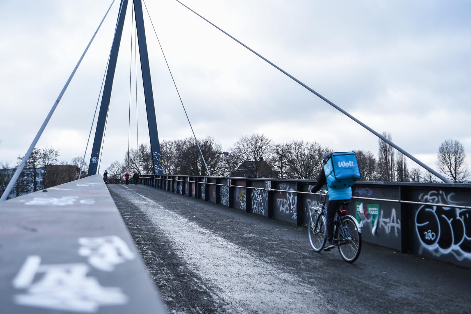 Einsamer Essensbote auf einer Fußgängerbrücke in Berlin: Weil die Infektionszahlen nicht sinken, könnte der harte Lockdown bis in den März verlängert werden.