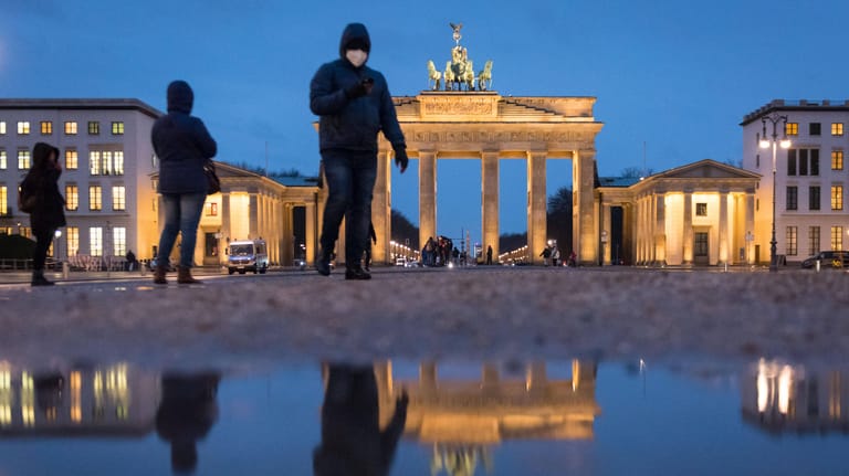 Nach dem Regen spiegelt sich das Brandenburger Tor in einer Pfütze: Bei einem möglichen "echten" Lockdown werden hier noch nicht mal mehr Touristen zu sehen sein.