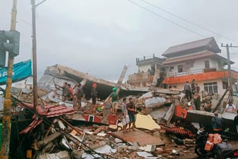 Anwohner inspizieren beschädigte Gebäude auf der indonesischen Insel Sulawesi. Bei einem Erdbeben der Stärke 6,2 sind mindestens drei Menschen ums Leben gekommen.
