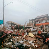 Anwohner inspizieren beschädigte Gebäude auf der indonesischen Insel Sulawesi. Bei einem Erdbeben der Stärke 6,2 sind mindestens drei Menschen ums Leben gekommen.