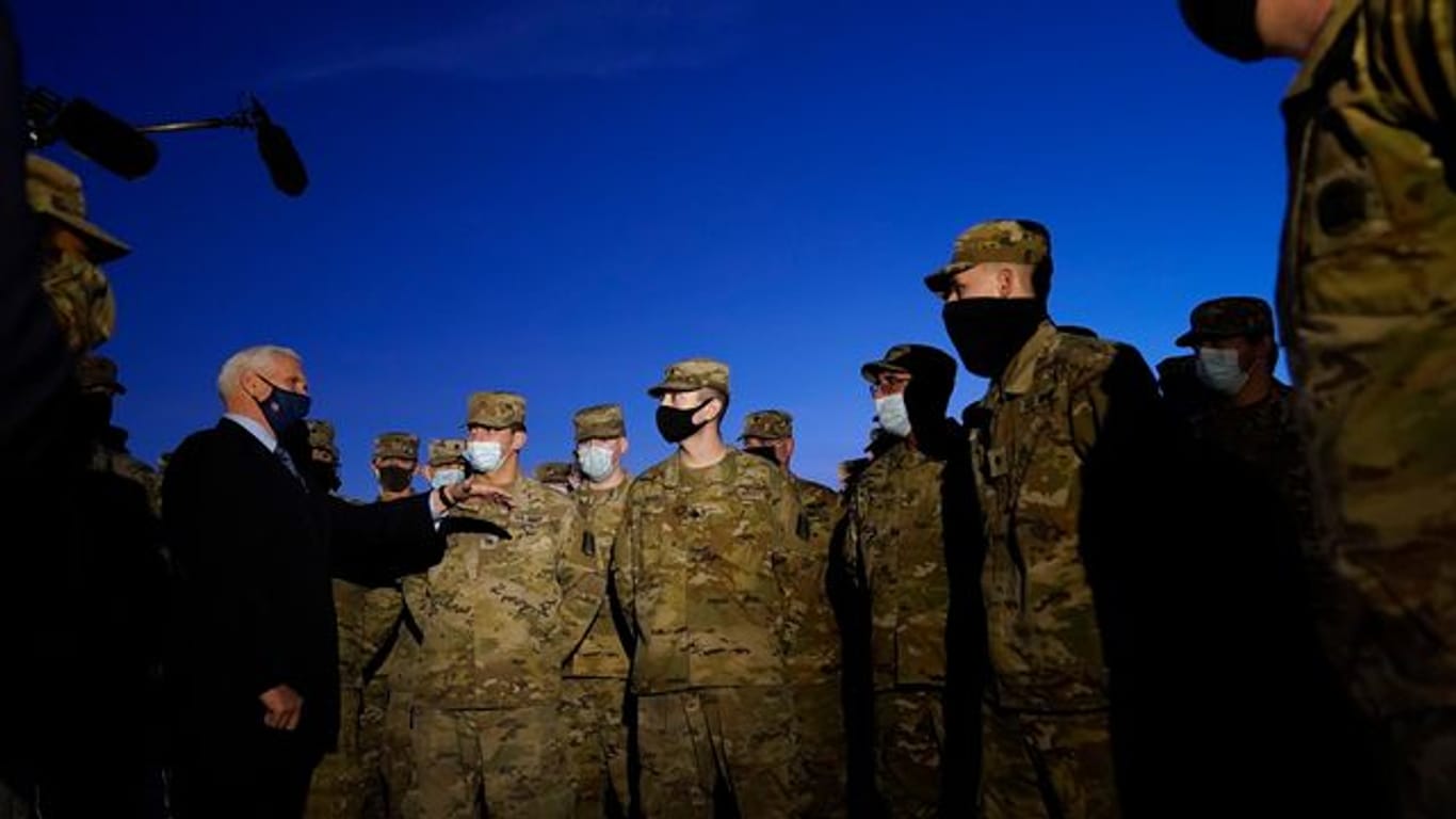US-Vizepräsident Mike Pence (l) spricht mit Truppenmitgliedern der Nationalgarde vor dem Kapitol in Washington.
