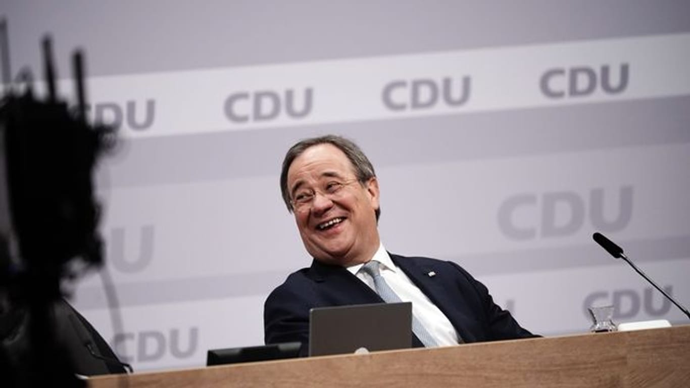 Der neue Parteivorsitzende Armin Laschet sitzt beim digitalen CDU-Bundesparteitag auf dem Podium.