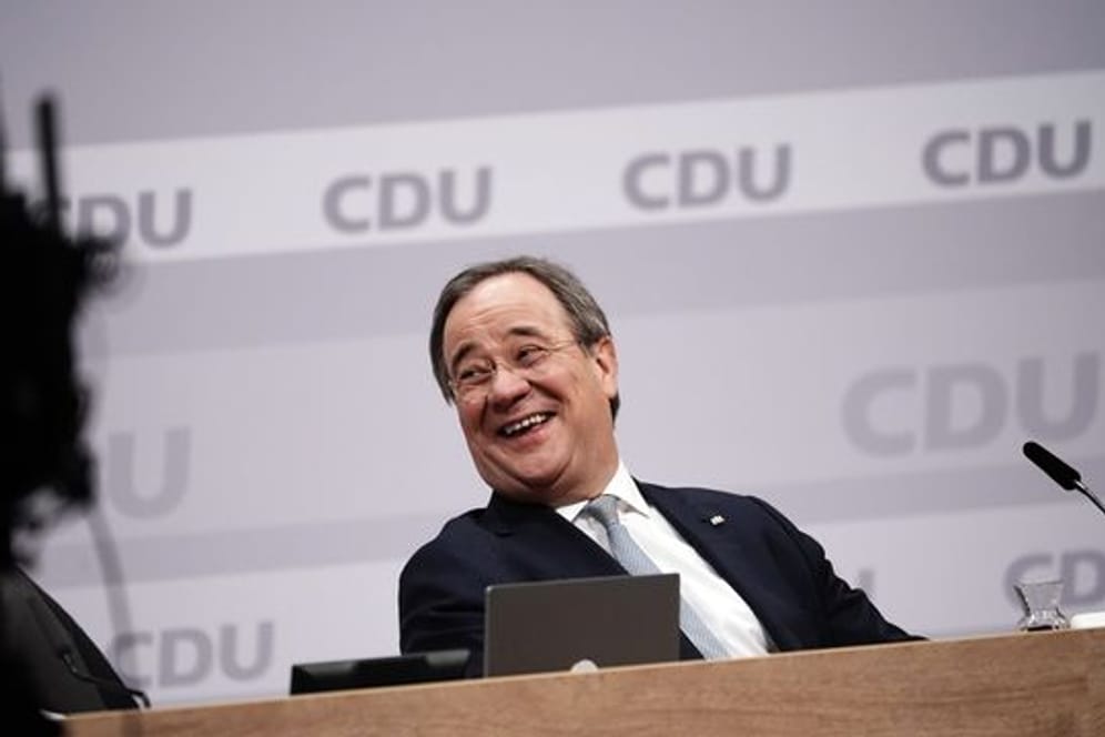 Der neue Parteivorsitzende Armin Laschet sitzt beim digitalen CDU-Bundesparteitag auf dem Podium.
