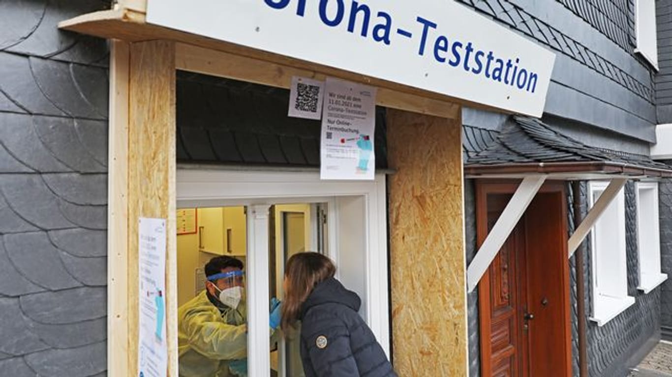 Ein Apotheker nimmt von einer Frau einen Abstrich an einer Corona-Teststation in Wipperfürth.