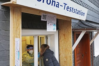 Ein Apotheker nimmt von einer Frau einen Abstrich an einer Corona-Teststation in Wipperfürth.