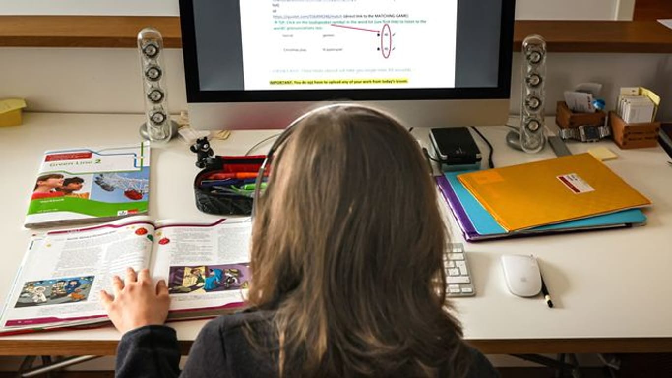 Ein zwölfjähriger Gymnasiast löst am Computer in seinem Zuhause seine Schulaufgaben, die ihm seine Lehrer für jeden Tag über den Schulserver geschickt haben.