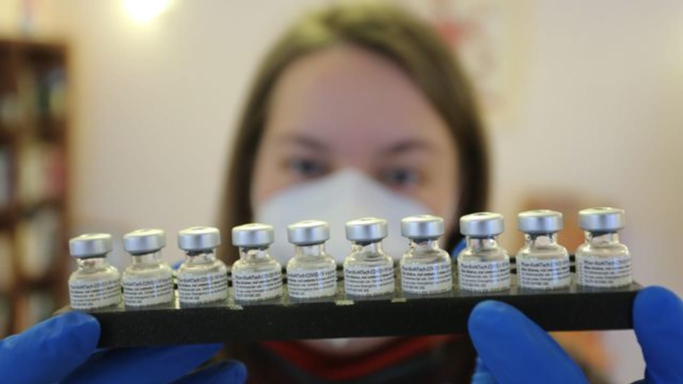 Ein Mitarbeiterin eines mobilen Impfteams in Halberstadt hält ein Tablett mit Impffläschchen der Firma Biontech/Pfizer.