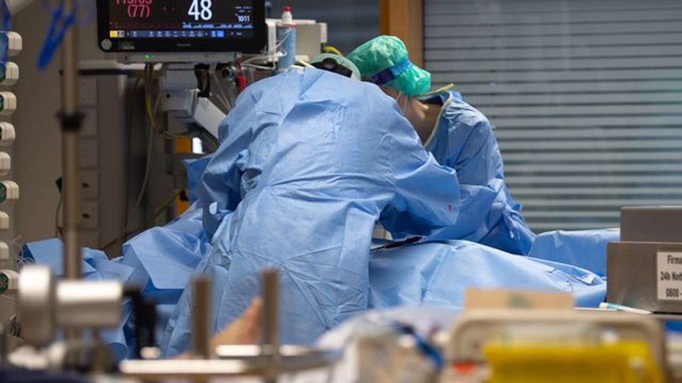 Medizinisches Personal legt auf einer Intensivstation einem Covid-19-Patienten einen Zugang für die künstliche Beatmung.