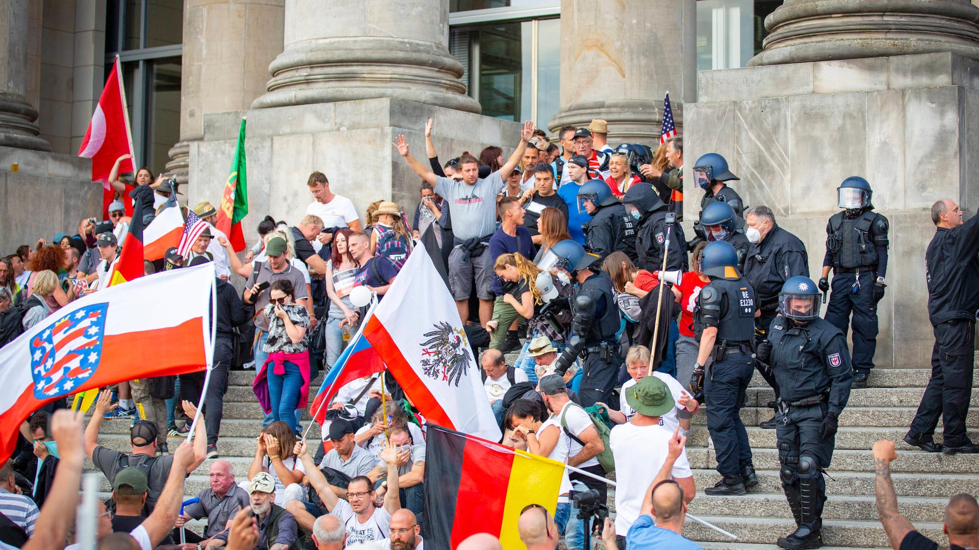 Polizisten räumen im August 2020 die besetzte Reichstagstreppe: Nach dem versuchten "Sturm auf den Reichstag" geht die Polizei nun gegen mutmaßliche Krawallmacher vor. Polizisten räumen im August 2020 die besetzte Reichstagstreppe: Nach dem versuchten "Sturm auf den Reichstag" geht die Polizei nun gegen mutmaßliche Krawallmacher vor.