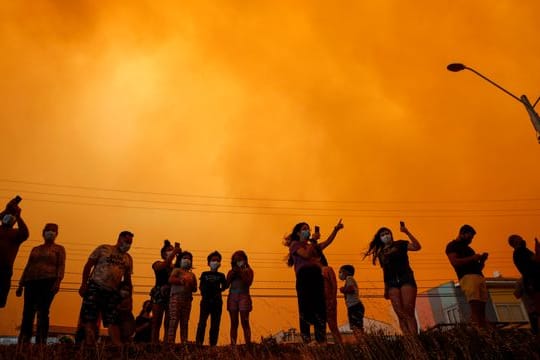 Anwohner beobachten in Quilpué die durch den Waldbrand ausgelösten Rauchwolken am Himmel.