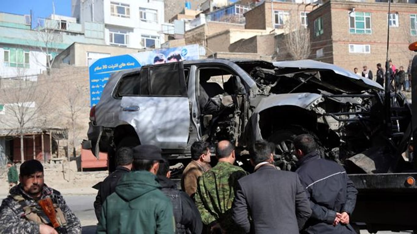 Afghanische Sicherheitsbeamte inspizieren den Ort eines Bombenanschlags in Kabul, bei dem zwei Polizisten getötet wurden.