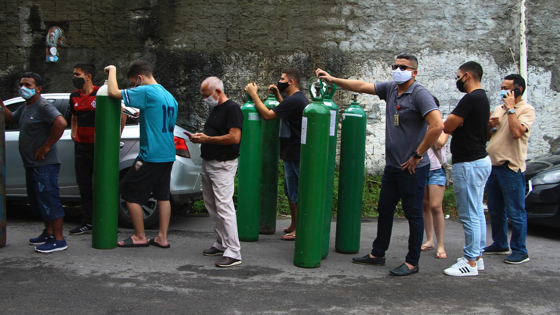 Menschen stehen bei der Firma Nitron da Amazonia in Manaus an, um Sauerstoffflaschen für ihre Familienmitglieder im Krankenhaus auffüllen zu lassen.