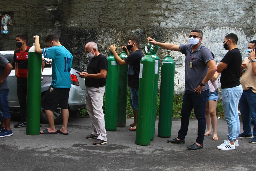 Menschen stehen bei der Firma Nitron da Amazonia in Manaus an, um Sauerstoffflaschen für ihre Familienmitglieder im Krankenhaus auffüllen zu lassen.