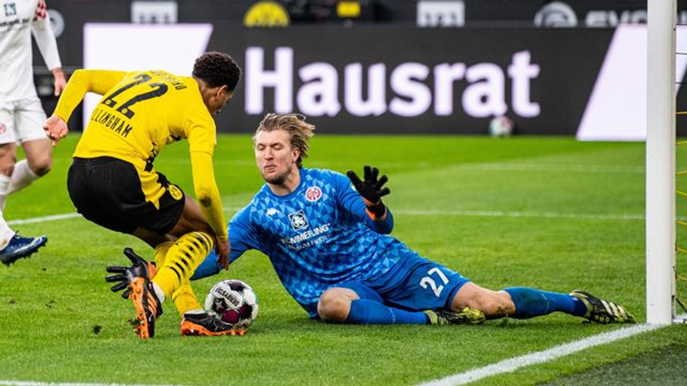Der Mainzer Torwart Robin Zentner (r) sptitzelt Dortmunds Jude Bellingham den Ball vom Fuß.