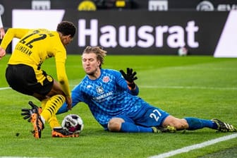 Der Mainzer Torwart Robin Zentner (r) sptitzelt Dortmunds Jude Bellingham den Ball vom Fuß.