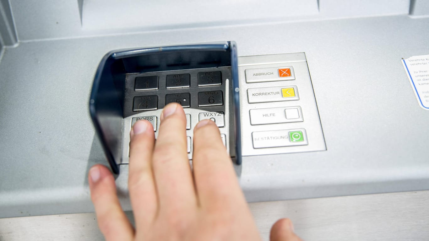 Eine Person gibt ihre PIN ein (Symbolbild): In Deutschland werden immer seltener Daten am Bankautomaten gestohlen.