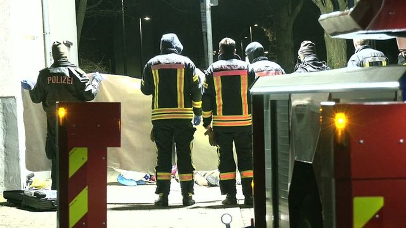 Feuerwehrleute errichten am Tatort einen Sichtschutz.
