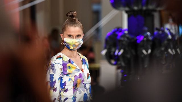 Ein Model mit Maske zeigt Mode aus Anja Gockels neuer Kollektion. Ein Model mit Maske zeigt Mode aus Anja Gockels neuer Kollektion.