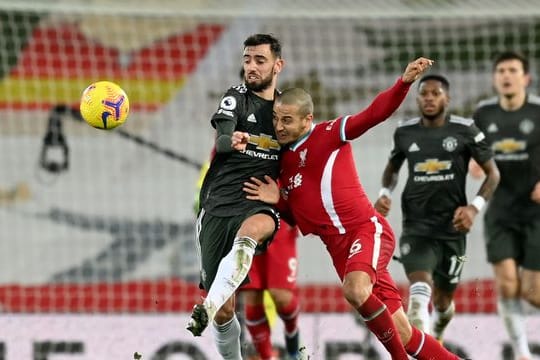 Manchesters Bruno Fernandes (l) kämpft mit Liverpools Thiago (2.