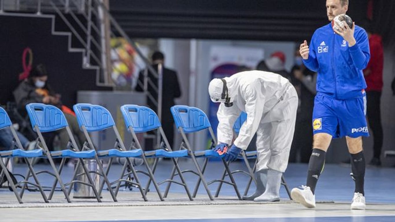 Ein Mitglied des Corona-Desinfektionsteams desinfiziert Stühle vor der WM-Partie Österreich gegen Frankreich.
