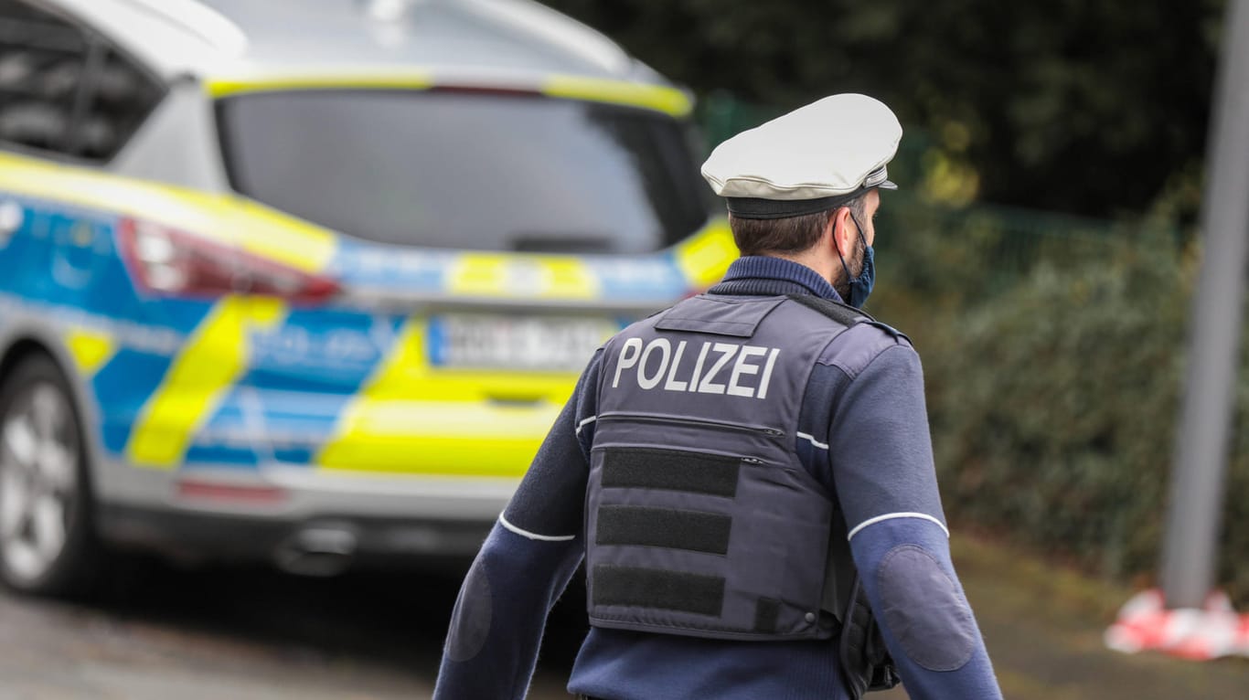 Ein Polizist vor einem Streifenwagen in Wuppertal (Symbolbild): Zwei Beamte sind im Einsatz angegriffen worden.