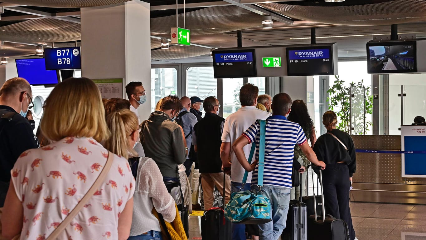 Passagiere warten in Düsseldorf vor dem Einchecken (Symbolbild): Am Flughafen sollen bald Corona-Schnelltests zum normalen Ablauf gehören.