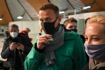 Alexej Nawalny und seine Frau Julia stehen am Flughafen Scheremetjewo: Am Montag fand sich der Kreml-Kritiker plötzlich vor einem Gericht in einem Polizeigebäude wieder.