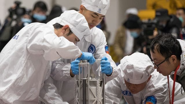 Chinesische Wissenschaftler in Peking beim Wiegen der Gesteinsproben vom Mond. Chinesische Wissenschaftler in Peking beim Wiegen der Gesteinsproben vom Mond.