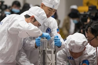 Chinesische Wissenschaftler in Peking beim Wiegen der Gesteinsproben vom Mond.