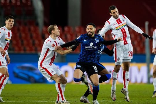 Berlins Matheus Cunha (M) und Kölns Ellyes Skhiri (r) versuchen an den Ball zu kommen.