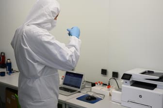 Ein Mitarbeiter der Firma CoviMedical UG wertet in einem Corona-Testcenter auf einem Rasthof einen Corona-Schnelltest aus (Archivbild). Experten fordern mehr Tests und Sequenzierungen.
