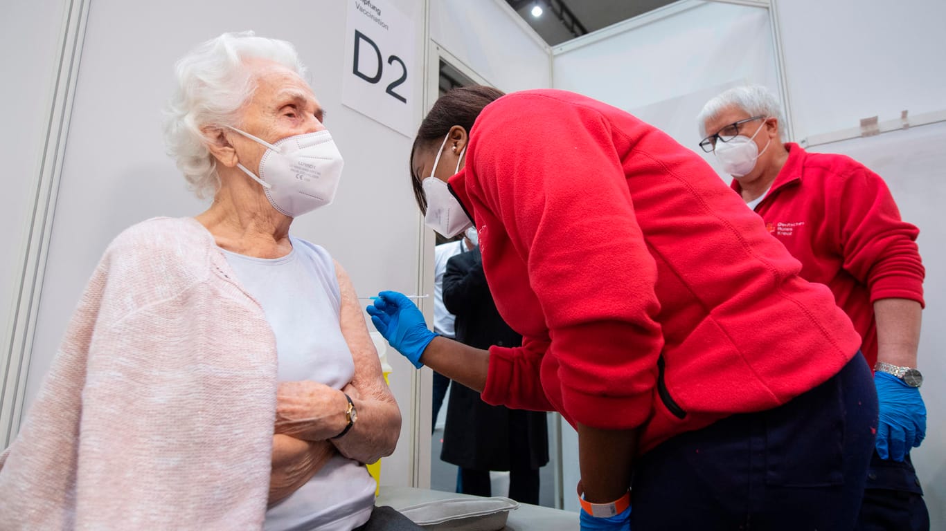 Eine Ärztin impft die 90-jährige Odores H. (l.) in der Festhalle in Frankfurt gegen das neuartige Coronavirus: Am ersten Tag des regulären Betriebs sollen hier rund 500 Menschen gegen Corona geimpft werden.