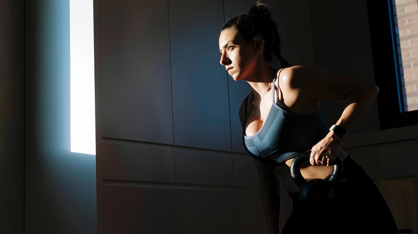 Eine Sportlerin hält sich mit Gewichten fit: Geräte fürs Heimtraining erleben in der Corona-Krise einen Preissprung.