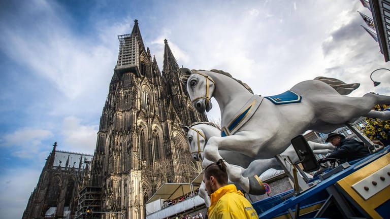 Rosenmontagszug vor dem Kölner Dom: Vor allem in Karnevalsliedern wird auf Kölsch gesungen.