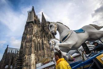Rosenmontagszug vor dem Kölner Dom: Vor allem in Karnevalsliedern wird auf Kölsch gesungen.
