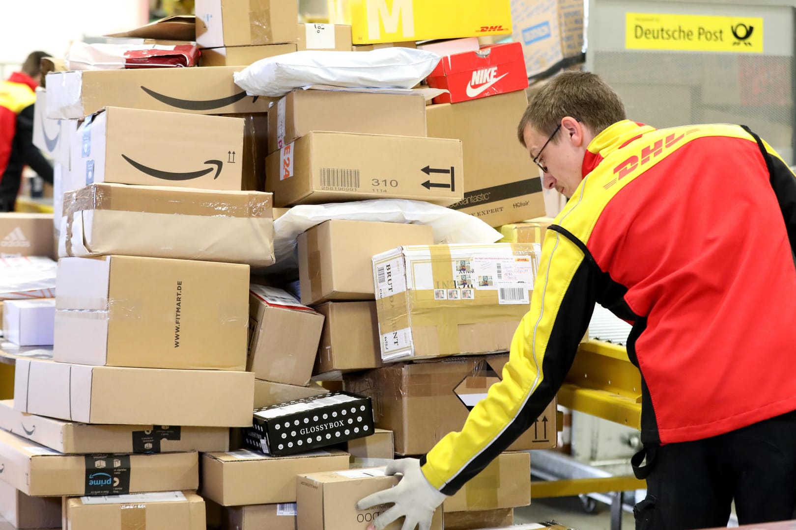 Ein DHL-Mitarbeiter sortiert Pakete (Archivbild): Die Corona-Pandemie hat den Paket-Boom weiter angeheizt. Ein DHL-Mitarbeiter sortiert Pakete (Archivbild): Die Corona-Pandemie hat den Paket-Boom weiter angeheizt.