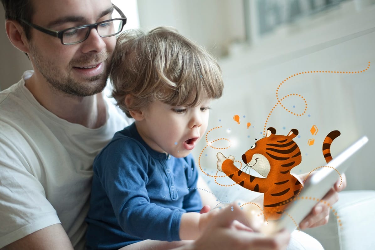 Vater und Sohn schauen auf ein Tablet (Symbolbild): Die App "TigerBooks" bietet Kindern digitalen Zugang zu ihren Helden.