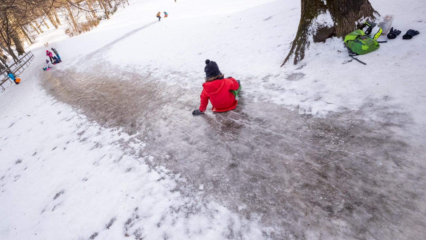Ein Kind rutscht einen vereisten Hügel hinab (Symbolbild): Ein Sechsjähriger ist beim Schlittenfahren in München schwer verletzt worden.