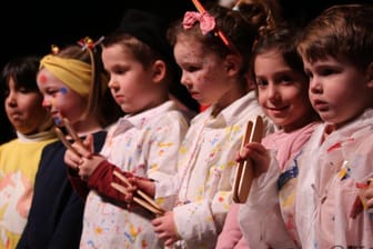 Kinder halten Kleppern in den Händen: Eine Klepper ist ein Lärminstrument mit dem der Winter und böse Geister vertrieben werden sollen.