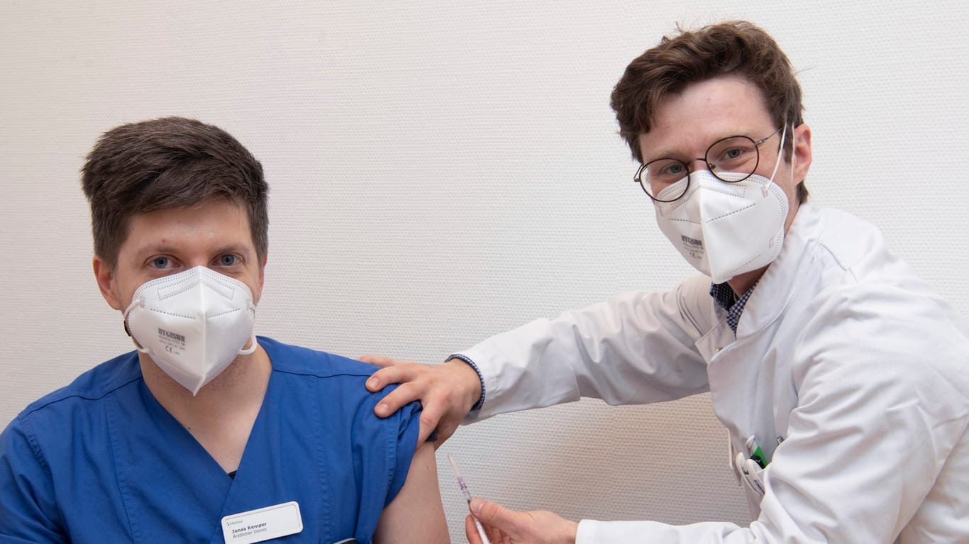 Am Helios Universitätsklinikum in Wuppertal krempelten die Mitarbeiterinnen und Mitarbeiter gegen Corona die Ärmel hoch: Sebastian Bender, Assistenzarzt Dermatologie impft einen Mitarbeiter.