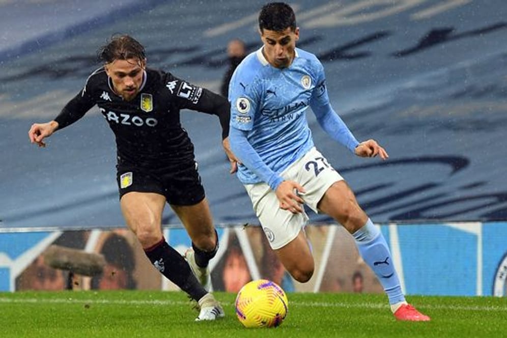 Joao Cancelo (r) von Manchester City und Aston Villas Matty Cash kämpfen um den Ball.