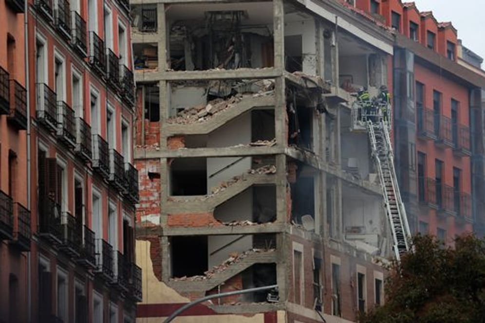 Feuerwehrleute arbeiten nach der schweren Explosion an dem beschädigten Gebäude in Madrids Toledo Straße.