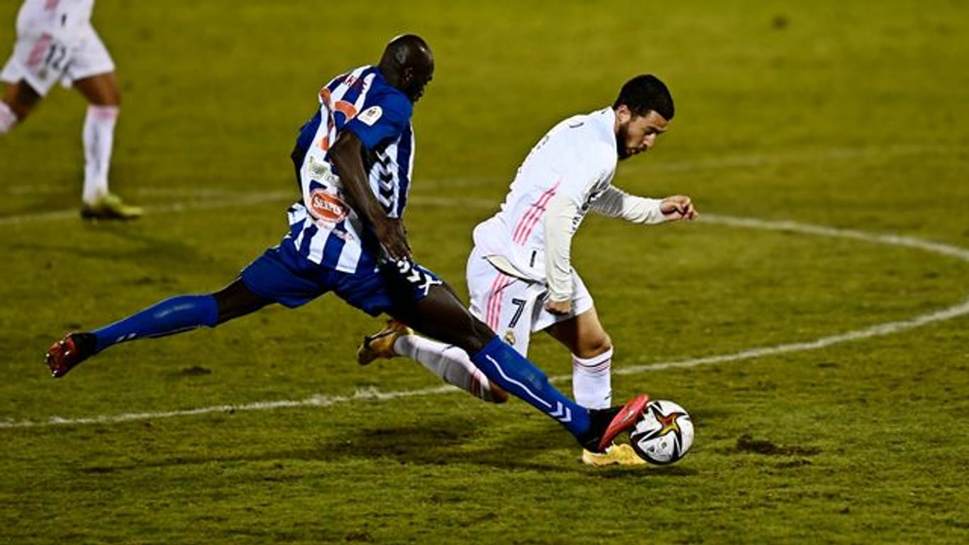 Ali Diakite (l) von CD Alcoyano stoppt Madrids Eden Hazard mit einer beherzten Grätsche.