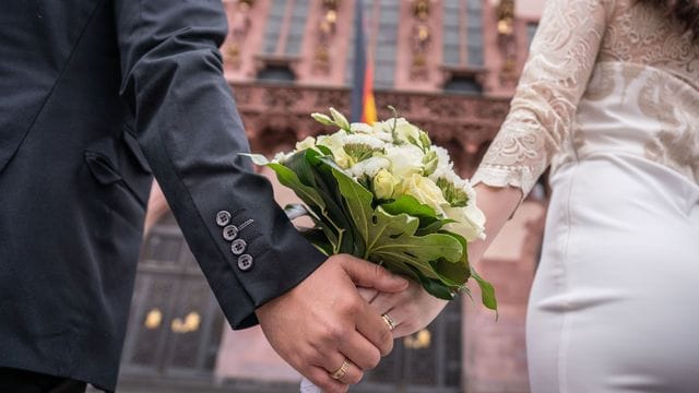 Ein Brautpaar steht nach der standesamtlichen Trauung auf dem Römerberg in Frankfurt. Ein Brautpaar steht nach der standesamtlichen Trauung auf dem Römerberg in Frankfurt.