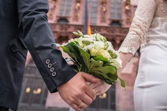 Ein Brautpaar steht nach der standesamtlichen Trauung auf dem Römerberg in Frankfurt.