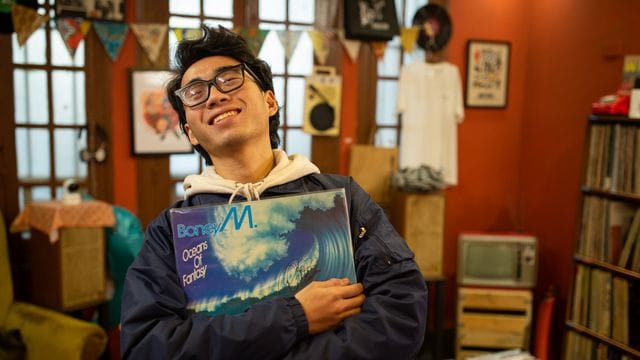 Hung, Mitarbeiter des LP Club, hält die Schallplatte "Oceans of Fantasy" von Boney M. Hung, Mitarbeiter des LP Club, hält die Schallplatte "Oceans of Fantasy" von Boney M.